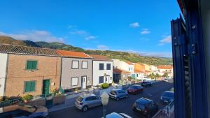 a view of a street with parked cars and houses at Hamilton House in Vila Franca do Campo