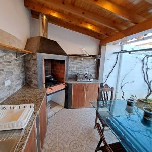 a kitchen with a stone oven and a table at Hamilton House in Vila Franca do Campo