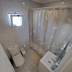 a bathroom with a toilet and a shower curtain at Hamilton House in Vila Franca do Campo