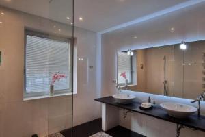 a bathroom with two sinks and a large mirror at Haus mit traumhaften Ausblick in die Natur in Purkersdorf