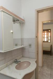 een badkamer met een wastafel en een spiegel bij Casa com churrasqueira prox a Praia de Cidreira RS in Cidreira