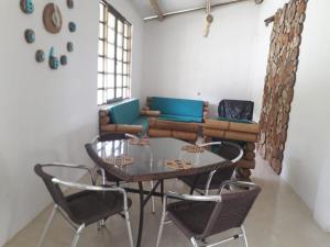 una mesa y sillas en una habitación con sofá en El Guadual Casa Campestre, en Ibagué