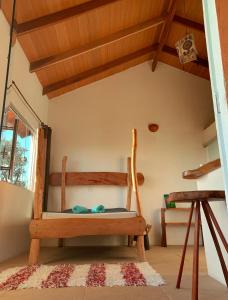 a room with a wooden chair and a window at Chalé jatobá, venha viver essa experiência!!! in Alto Paraíso de Goiás