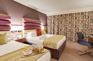 a hotel room with two beds and a table with a tray of food at Lea Marston Hotel in Lea Marston +43 photos