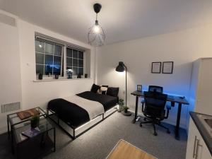 a bedroom with a bed and a desk in it at Comfortable modern (SMART) Studio in Walthamstow. in London