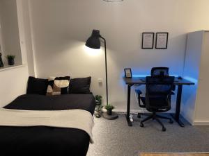 1 dormitorio con escritorio, 1 cama y escritorio con silla en Comfortable modern (SMART) Studio in Walthamstow. en Londres