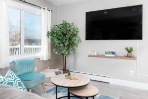 a living room with a couch and a table and a tv at Modern & Stylish 2-Bedroom Unit in Edmonton