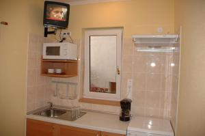 a small kitchen with a sink and a microwave at Apartment Pension Rideg Heviz in Hévíz +58 photos