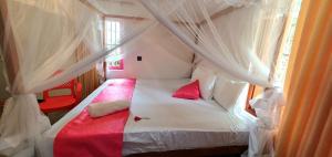 une chambre avec un lit blanc avec des oreillers rouges dans l'établissement Villa Tamarind Shade - Talalla, à Talalla South