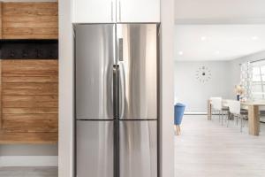 a stainless steel refrigerator in a kitchen with a dining room at Modern & Elegant 1-Bedroom Unit in Edmonton