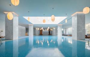 a large pool with blue water in a building at Oaks Chengdu at Cultural Heritage Park in Chengdu