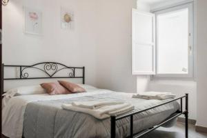 ein Schlafzimmer mit einem Bett mit einem schwarzen Rahmen und einem Fenster in der Unterkunft B&B CORSO VITTORIO EMANUELE - Nel pieno centro storico in LʼAquila