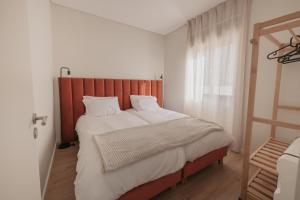 um quarto com uma cama grande e uma cabeceira em madeira em Albina's Guest House em Leça da Palmeira