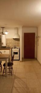 a kitchen with a table and a stove top oven at Departamentos Centro Dpto 6 1 habitacion in Tandil