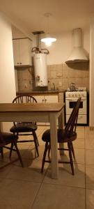 cocina con mesa de madera y 2 sillas en Departamentos Centro Dpto 6 1 habitacion en Tandil