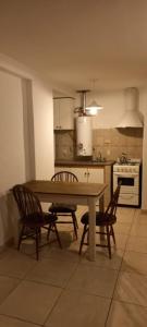 a kitchen with a table and chairs and a stove at Departamentos Centro Dpto 6 1 habitacion in Tandil