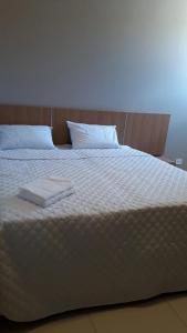 - un lit blanc avec 2 serviettes dans l'établissement Pousada Recanto Gentil, à Triunfo
