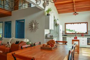 un salon avec une table en bois et un canapé dans l'établissement Linda vista para as montanhas a 5 min da cidade, à Santo Antônio do Pinhal