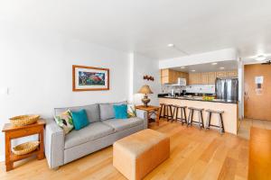 a living room with a couch and a kitchen at Ilikai Marina 1BR Condo, Ocean View Haven in Honolulu