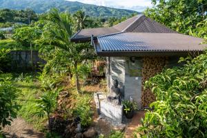 ein kleines Haus inmitten eines Gartens in der Unterkunft KIA ORA LODGE in Afaahiti