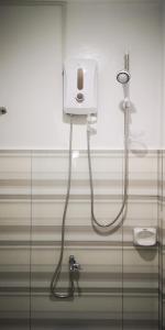 a shower in a bathroom with a hose plugged in at Rain Haven Lodging House in Coron