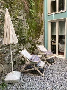 two chairs and an umbrella next to a building at Casas das Caldeiras in Porto