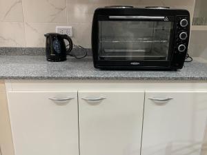 un microondas negro sentado en la parte superior de una barra de cocina en ALVARADO en Salta