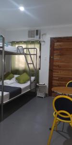 Zimmer mit Etagenbetten, einem Tisch und einem Stuhl in der Unterkunft Rain Haven Lodging House in Coron