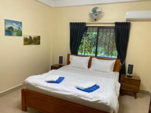 a bedroom with a bed with blue slippers on it at Villa Blue Lagoon in Sihanoukville