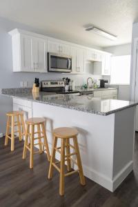 a kitchen with white cabinets and a counter with stools at New King Bed Beautifully Updated KMC1312 in Manhattan