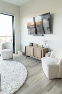 sala de estar con muebles blancos y espejo grande en Beautiful Colbert Hills Apartment, Great Location, Wonderful Views KMF3022, en Manhattan