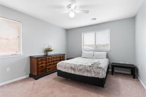 a bedroom with a bed and a dresser and two windows at End Unit, King Bed, Garage and Free Parking KMN1312 in Manhattan