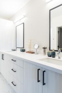 Baño blanco con 2 lavabos y 2 espejos en Beautiful Colbert Hills Apartment, Great Location, Wonderful Views KMF3022, en Manhattan