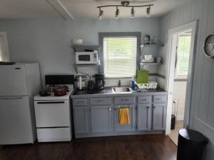 uma cozinha com um lavatório e um frigorífico branco em Beautiful Getwaway, Big Back Yard, Huge Side Yard KSQ5616 em Shawnee