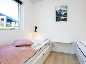 a white bedroom with a bed and a window at Holiday home Sjølund XXII in Sjølund
