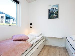 a white bedroom with a bed and a window at 10 person holiday home in Sjølund-By Traum in Sjølund