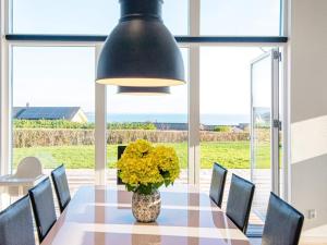 a dining room with a table with a vase of flowers at Holiday home Sjølund XXII in Sjølund