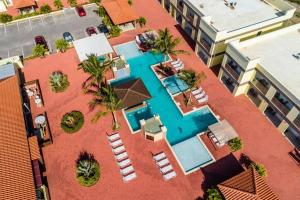 een uitzicht over het zwembad met ligstoelen en stoelen bij Aruba Condo The Pearl - At Eagle Beach - minute walk! in Palm-Eagle Beach