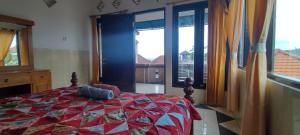 um quarto com uma cama e uma grande janela em Harmony Guest House em Padangbai