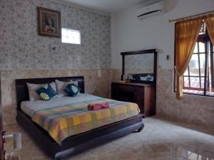 Un dormitorio con una cama con lavabo y espejo. en Harmony Guest House, en Padangbai