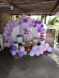 a table with purple and white balloons and food at Two crazy monkeys in Bakjawan +27 photos