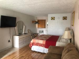 1 dormitorio con cama, sofá y TV en THE FLORIDIAN INN, en Clearwater