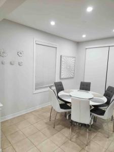 a dining room with a white table and chairs at Luxury 4-Bedrooms Home… in Brampton