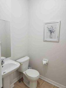 a white bathroom with a toilet and a sink at Luxury 4-Bedrooms Home… in Brampton