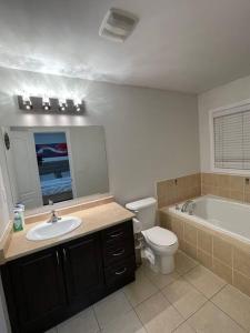 a bathroom with a sink and a toilet and a tub at Luxury 4-Bedrooms Home… in Brampton