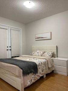 a white bedroom with a bed and a window at Luxury 4-Bedrooms Home… in Brampton
