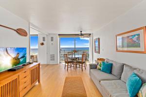 a living room with a couch and a tv and a table at Ilikai Marina 1BR Condo, Ocean View Haven in Honolulu