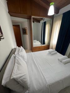 - une chambre avec un grand lit blanc et un miroir dans l'établissement Aθens Dome - Apartments by Live&Travel, à Athènes