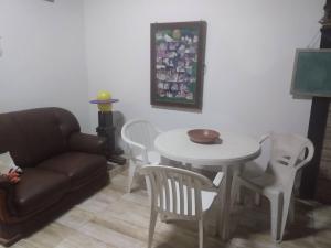 a living room with a couch and a table and chairs at Suite Aconchegante 01 in Saquarema