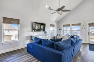 een woonkamer met een blauwe bank en een tv bij Seaward Breeze in Galveston